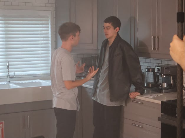 Nicolás Devoto in a leather jacket playing a kitchen confrontation