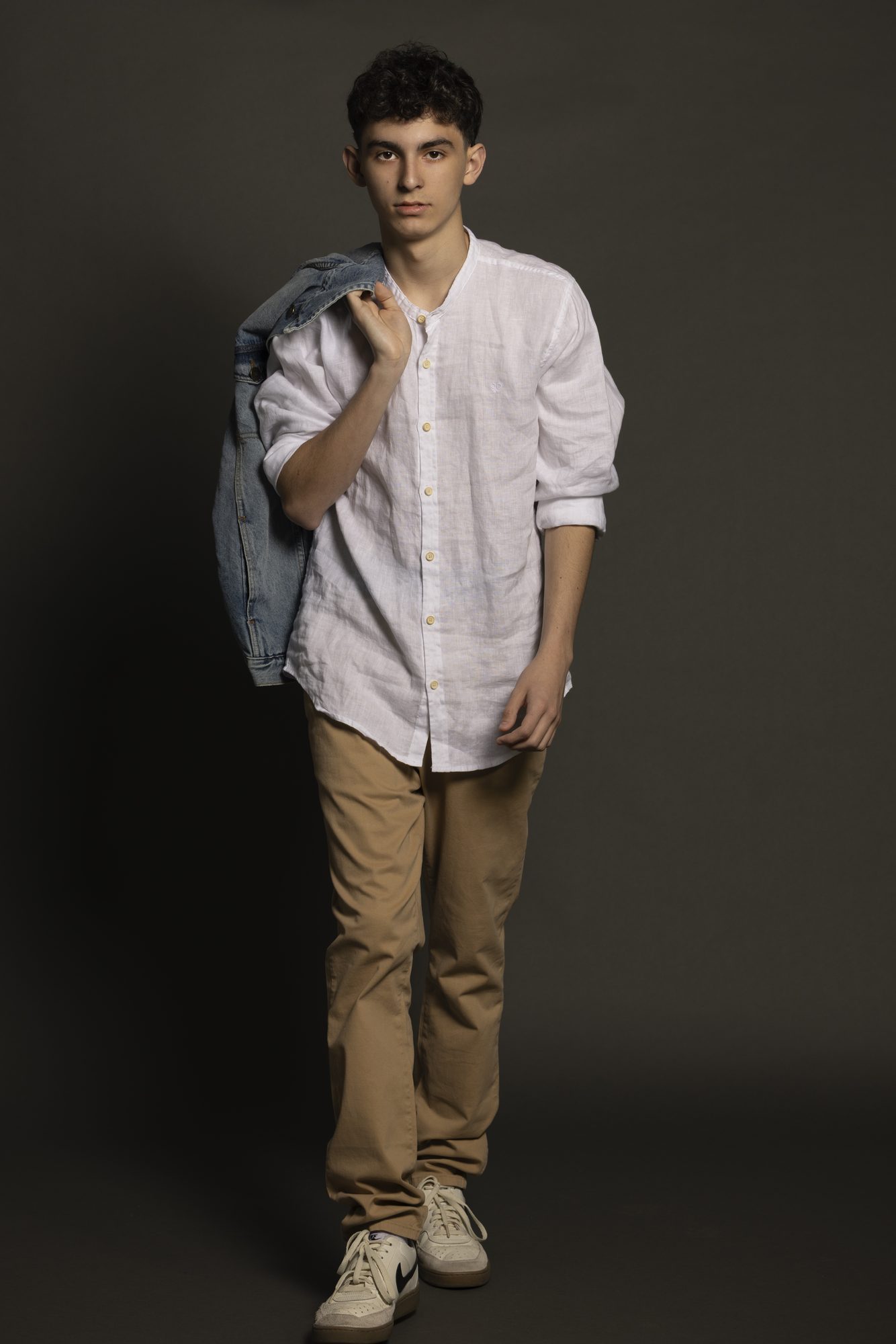 Nicolás Devoto full-length studio portrait with a denim jacket over his shoulder