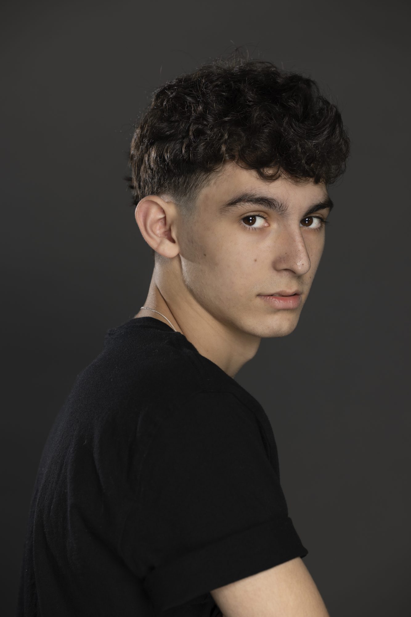 Nicolás Devoto looking back over his shoulder in a studio portrait